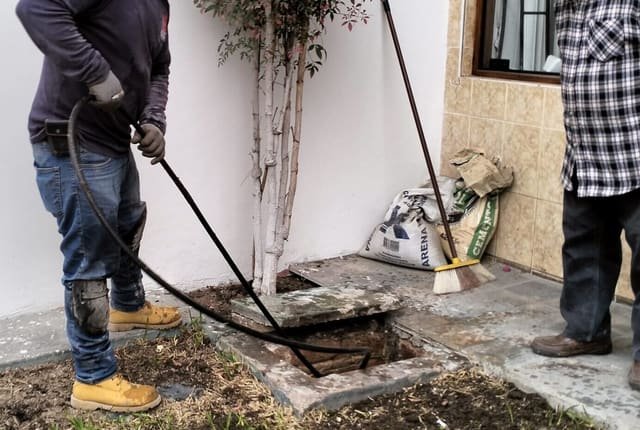 Técnico lavando una tubería con hidrolavadora de alta presión