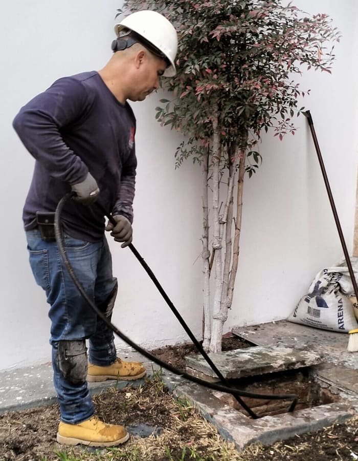 Técnico lavando una tubería con hidrolavadora de alta presión